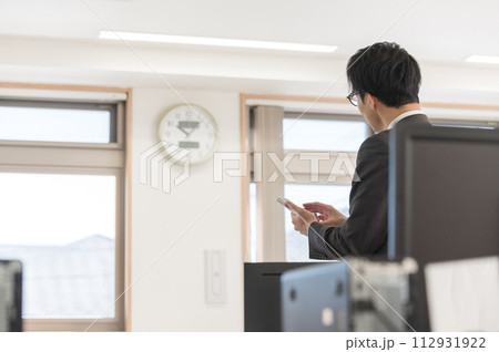 時間を気にするスーツ姿の男性ビジネスマン 時間を気にするスーツ姿の男性ビジネスマン 112931922