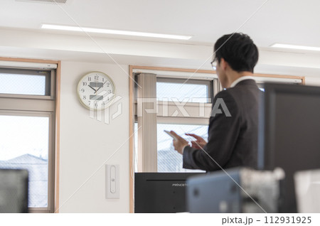 時間を気にするスーツ姿の男性ビジネスマン 112931925