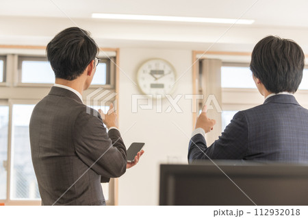 時間を気にするスーツ姿の男性ビジネスマン 112932018