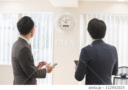 時間を気にするスーツ姿の男性ビジネスマン 112932025
