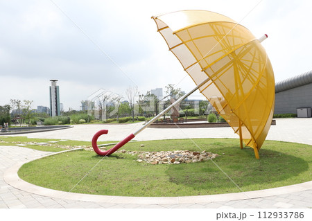 The shade of the big yellow parasol is cool. 112933786