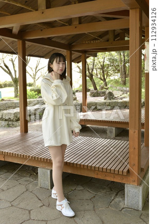 サクラ咲く公園でポーズをとる若い女性 112934126