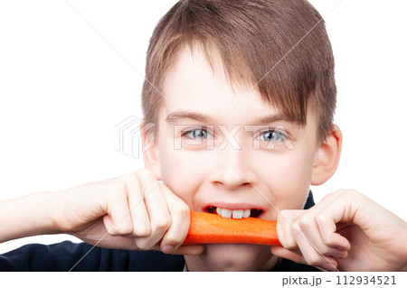 Boy biting carrot 112934521
