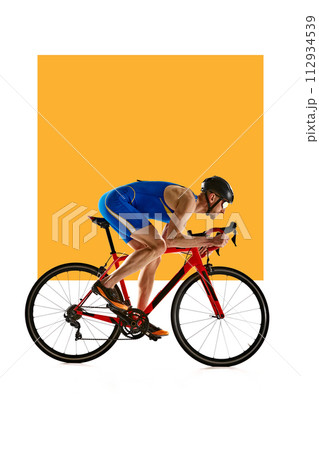 Concentrated and motivated man in sportswear and helmet, bicyclist in motion, training on white background with yellow element. 112934539