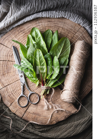 Fresh sorrel leaves on wooden plate 112936387