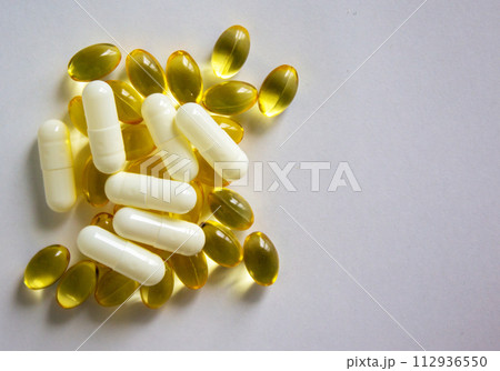 Medical concept. White and yellow pills isolated on beautiful white background. Web banner with a copy space. Medical concept. White and yellow pills isolated on beautiful white background. Web banner with a copy space. 112936550
