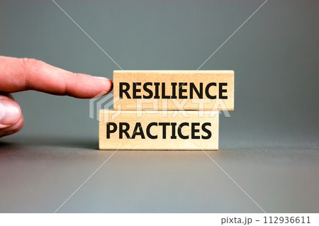 Resilience practices symbol. Concept word Resilience practices typed wooden blocks. Beautiful grey table grey background. Businessman hand. Business and resilience practices concept. Copy space. 112936611