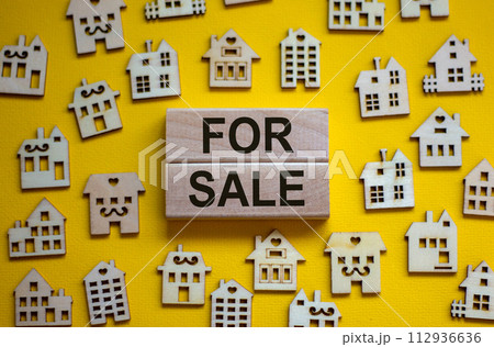 Wooden blocks form the words 'for sale', miniature wooden houses. Beautiful yellow background, copy space. Business concept. 112936636