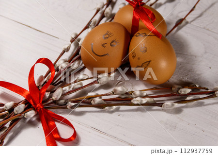 Easter composition with pussy willow twigs and eggs on white wooden table 112937759