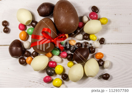 Easter composition with chocolate eggs on white wooden background Easter composition with chocolate eggs on white wooden background 112937780