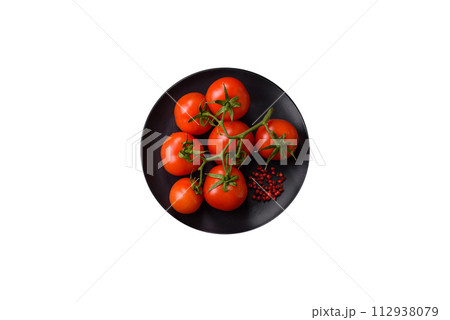Fresh red cherry tomatoes on a branch on a dark concrete background Fresh red cherry tomatoes on a branch on a dark concrete background 112938079