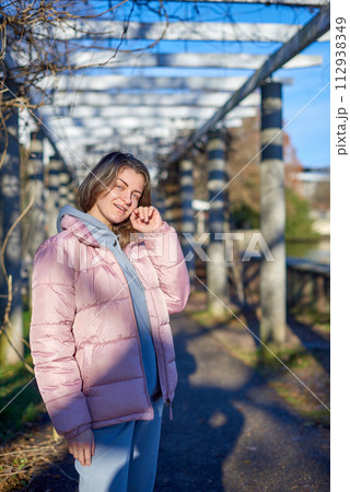 Winter Fun in Bitigheim-Bissingen: Beautiful Girl in Pink Jacket Amidst Half-Timbered Charm. a lovely girl in a pink winter jacket standing in the archway of the historic town of Bitigheim-Bissingen 112938349