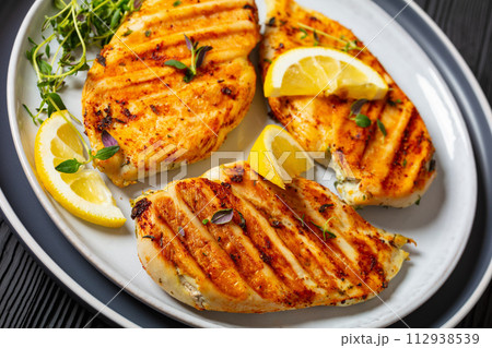 juicy grilled chicken cutlets on plate, top view 112938539
