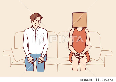 Indecisive man sits near woman with paper bag on head and is afraid of becoming acquainted Indecisive man sits near woman with paper bag on head and is afraid of becoming acquainted 112940378