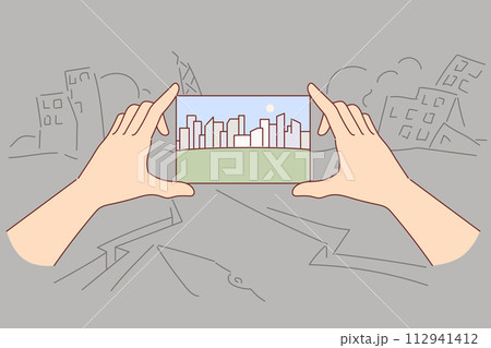 Beautiful city in photograph in hands, dreams of sustainable development stands in destroyed quarter Beautiful city in photograph in hands, dreams of sustainable development stands in destroyed quarter 112941412