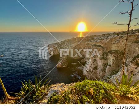 Beautiful sunset at Blue Grotto , complex of seven caves found along the southern coast of Malta. Beautiful sunset at Blue Grotto , complex of seven caves found along the southern coast of Malta. 112942052