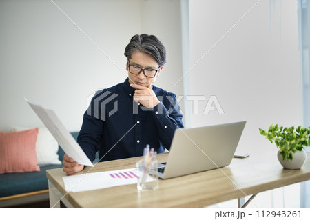 リビングでテレワークをするミドル男性 112943261