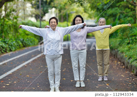ラジオ体操をする3人のシニアの女性 112943334