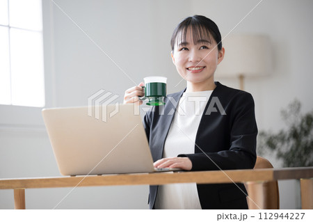 仕事中にコーヒーを飲む女性 カメラ目線 仕事中にコーヒーを飲む女性 カメラ目線 112944227