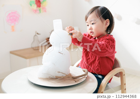 室内で雪だるまを飾る乳幼児 112944368