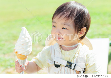 屋外でソフトクリームを食べる乳幼児 屋外でソフトクリームを食べる乳幼児 112944375