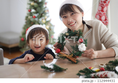 手作りのクリスマスリースを持つ親子 112944431
