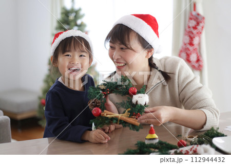 手作りのクリスマスリースを持つ親子 112944432