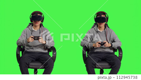 Gamer having fun with rpg games with modern devices over greenscreen background, participating in online gaming competition with friends. Asian man feeling relaxed with vr headset. 112945738