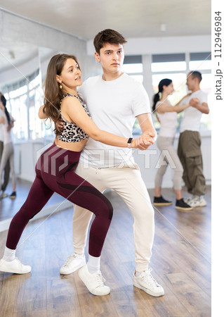 Young couple practicing passionate samba in dance class Young couple practicing passionate samba in dance class 112946984