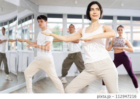 Team of dancers performing contemporary dance in choreography studio 112947216