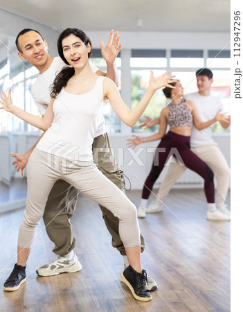 Joyful girl and guy performing lively Charleston together Joyful girl and guy performing lively Charleston together 112947296