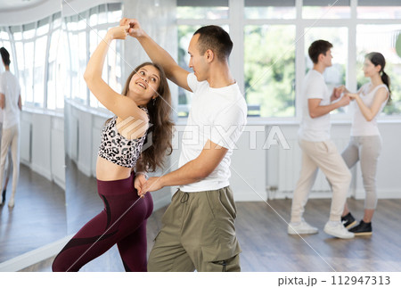 Young couple enjoying impassioned merengue in latin dance class 112947313