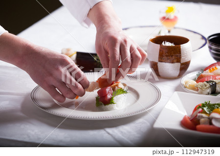 フレンチ料理人　盛り付けする手のアップ　料理を作る男性 112947319
