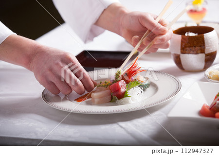 フレンチ料理人 盛り付けする手のアップ 料理を作る男性 フレンチ料理人 盛り付けする手のアップ 料理を作る男性 112947327