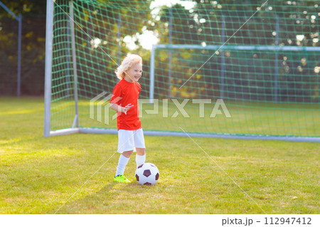 Kids play football. Child at soccer field. Kids play football. Child at soccer field. 112947412