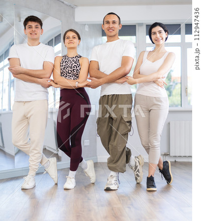 Group of young people stand in row holding hands, performing Irish folk dance. 112947436
