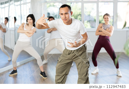 Team of dancers performing contemporary dance in choreography studio 112947483