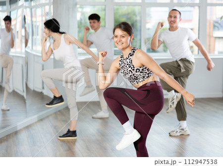 Girl with team of young like-minded people learn to dance modern dances 112947538