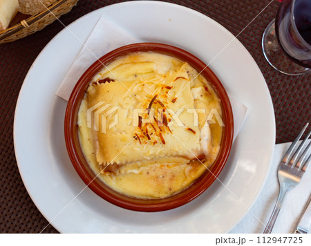 Meat lasagne with cheese served on platter 112947725