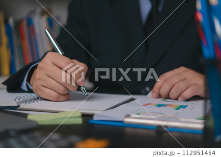 Male hand writing notes report marketing charts and financial graph data. Male hand writing notes report marketing charts and financial graph data. 112951454