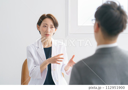 患者と話す女性医師 患者と話す女性医師 112951900