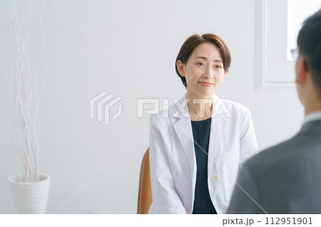 患者と話す女性医師 患者と話す女性医師 112951901