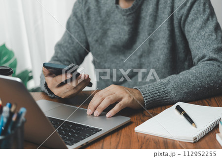 Businessman using mobile phone working and laptop computer digital internet network social media and data communication on desk. 112952255