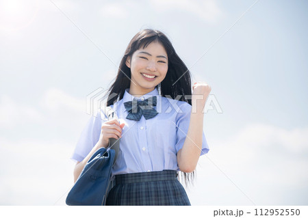 勉強を頑張る!青空背景で夏期講習や受験などのイメージに使いやすいガッツポーズの学生さん 勉強を頑張る!青空背景で夏期講習や受験などのイメージに使いやすいガッツポーズの学生さん 112952550