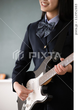ギターを演奏する学生　吹奏楽や部活のイメージ顔無しで使いやすい 手元のクローズアップ	 112952883