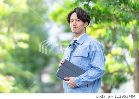 作業着の男性　屋外　新緑　タブレット 112953404
