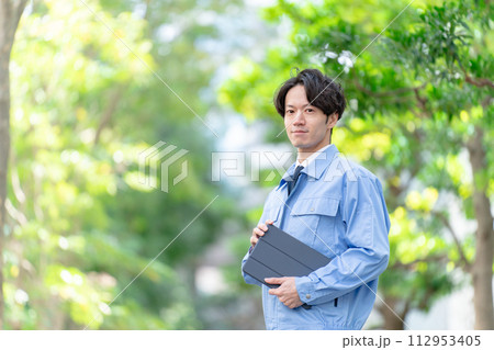 作業着の男性　屋外　新緑　タブレット 112953405