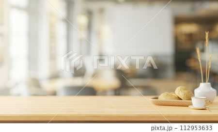A space on a wooden tabletop with a blurred background of a contemporary coffee shop. 112953633