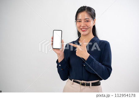 A beautiful Asian woman is pointing her index finger at a smartphone mockup in her hand. A beautiful Asian woman is pointing her index finger at a smartphone mockup in her hand. 112954178