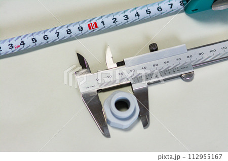 部品外形を測るノギスとメジャー 112955167
